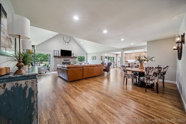 living room featuring a fireplace, a wealth of natural light, hardwood / wood-style floors, and lofted ceiling