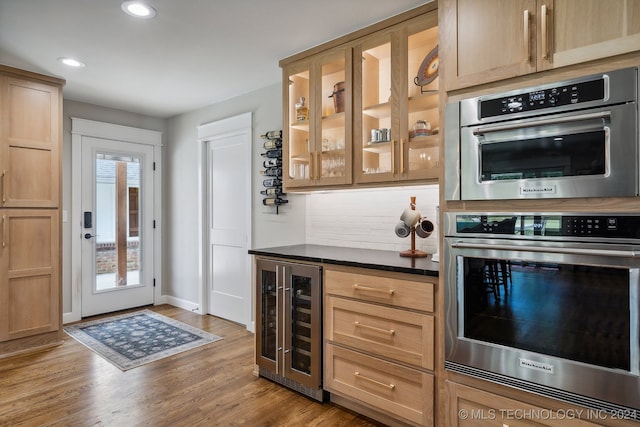 kitchen featuring hardwood / wood-style flooring, plenty of natural light, light brown cabinets, and beverage cooler