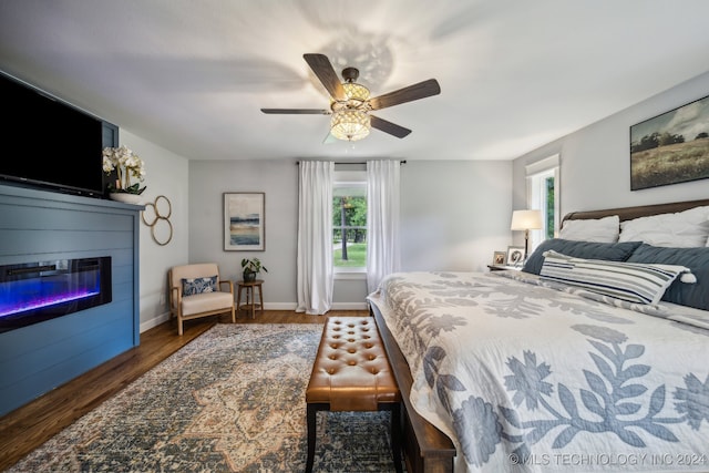 bedroom featuring multiple windows, dark hardwood / wood-style flooring, and ceiling fan