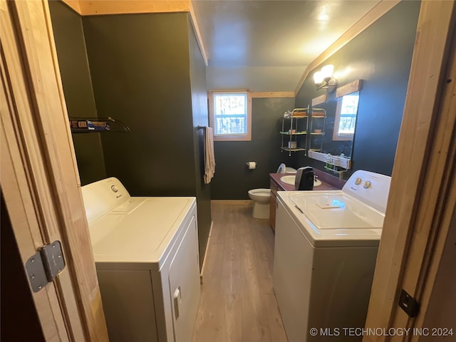 laundry area with plenty of natural light, light wood-type flooring, and separate washer and dryer