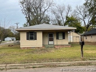 bungalow-style home with covered porch and a front yard