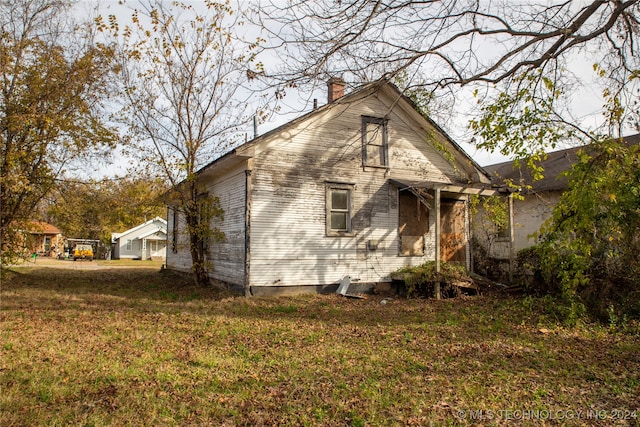 back of house featuring a lawn