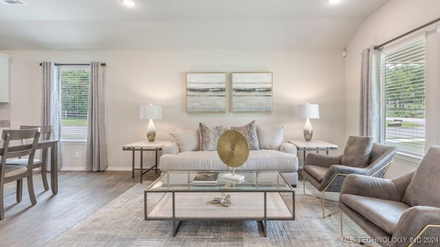 living room with light wood-type flooring and vaulted ceiling