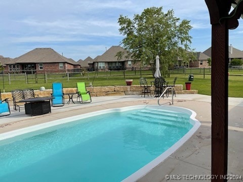 view of swimming pool with a lawn and a patio area