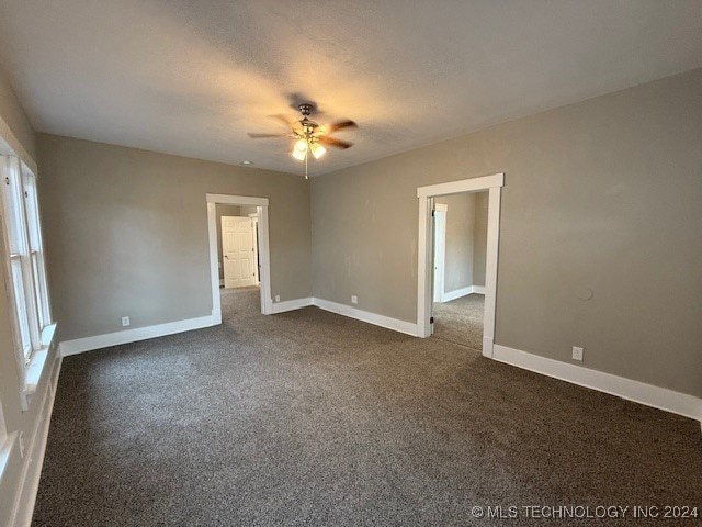 carpeted empty room featuring ceiling fan and a textured ceiling