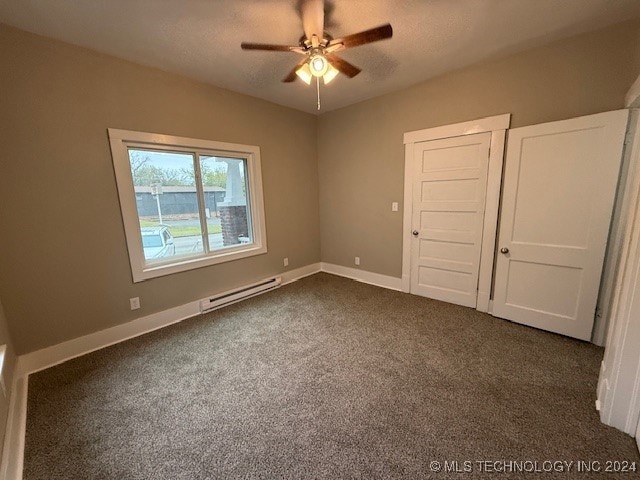 unfurnished bedroom featuring ceiling fan, a baseboard radiator, and dark carpet