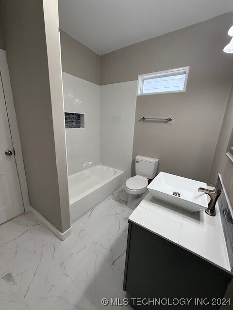 bathroom with walk in shower, vanity, and toilet