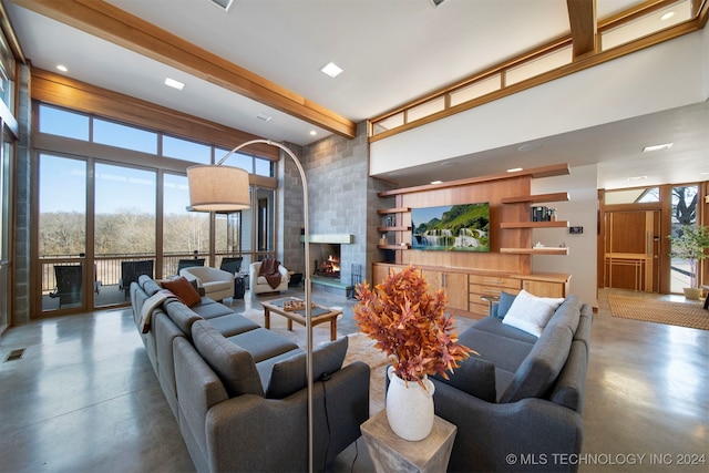 living room featuring a brick fireplace, a towering ceiling, and concrete floors