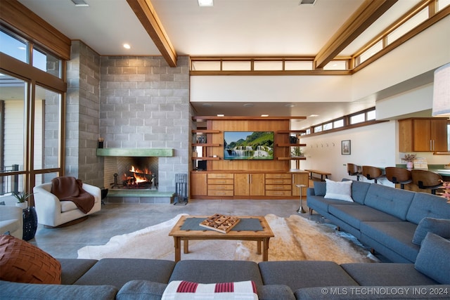 living room with beam ceiling, a fireplace, and a high ceiling