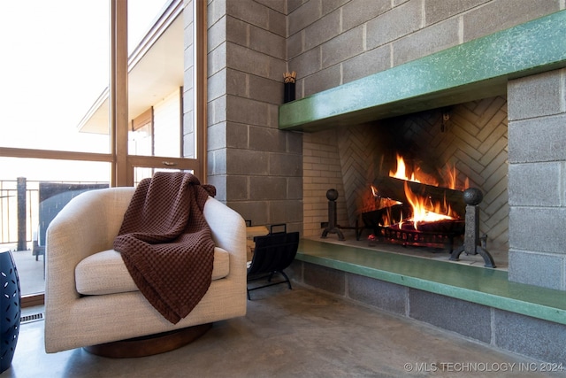 living area featuring concrete flooring and exterior fireplace