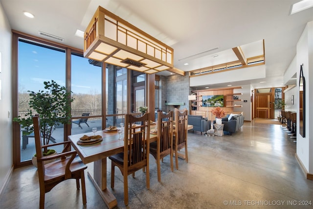 dining area featuring concrete flooring and a wall of windows