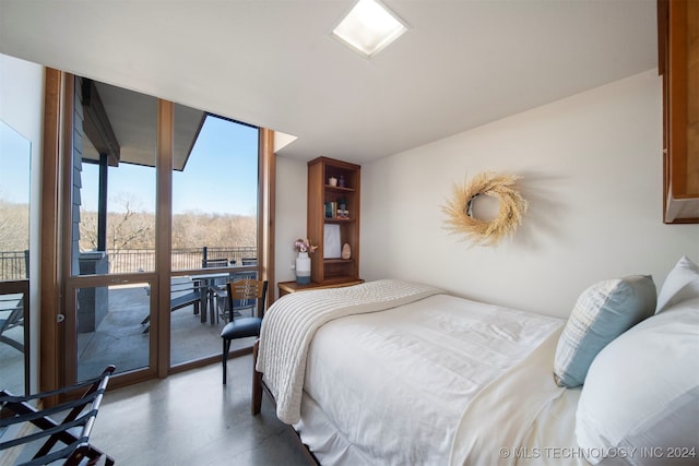 bedroom featuring expansive windows, access to outside, and concrete floors