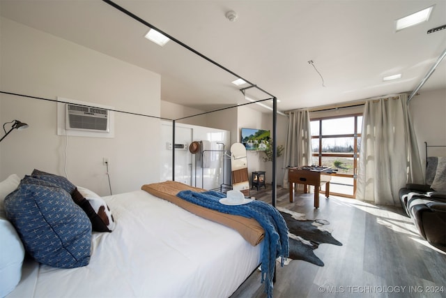 bedroom featuring hardwood / wood-style flooring and an AC wall unit