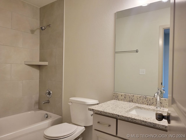 full bathroom with vanity, toilet, and tiled shower / bath