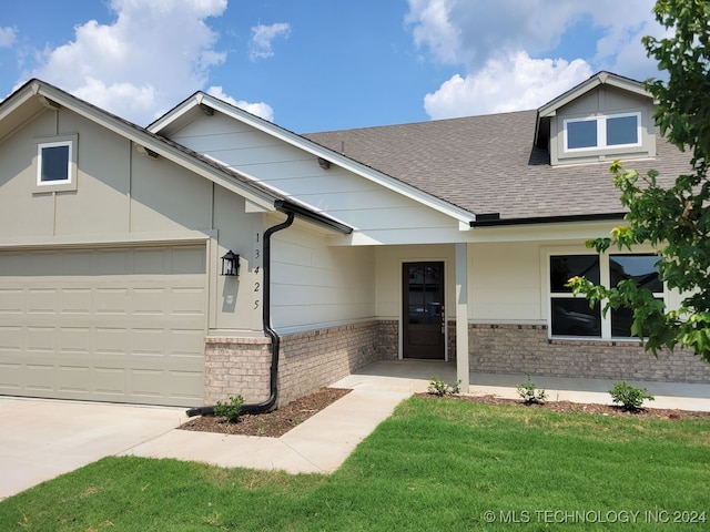 view of front of property featuring a front yard and a garage