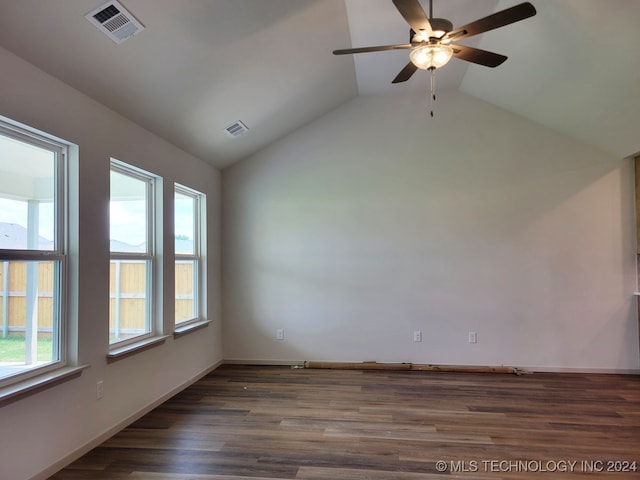 spare room featuring dark wood-type flooring, vaulted ceiling, ceiling fan, and a healthy amount of sunlight