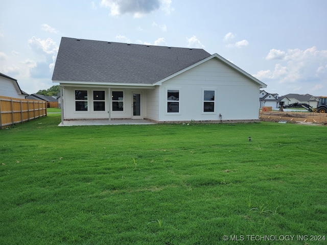 rear view of property with a yard and a patio