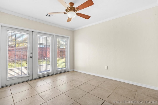 spare room featuring crown molding, french doors, light tile patterned flooring, and a healthy amount of sunlight