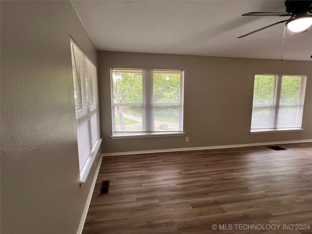 empty room with dark hardwood / wood-style floors and ceiling fan