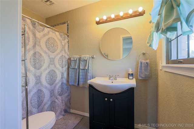 bathroom featuring tile patterned flooring, vanity, and toilet