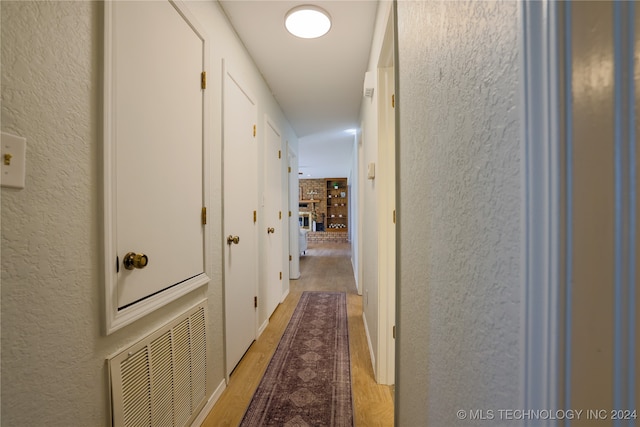 hallway with light hardwood / wood-style floors