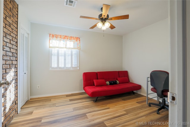 sitting room with light wood-type flooring and ceiling fan