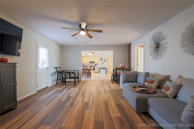 living room featuring wood-type flooring and ceiling fan