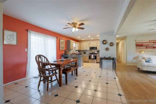 dining space with ceiling fan and light wood-type flooring