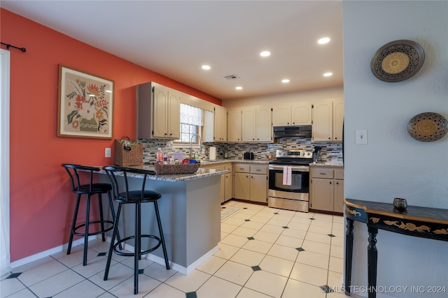 kitchen featuring a kitchen bar, decorative backsplash, kitchen peninsula, sink, and electric range