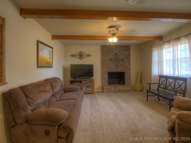 carpeted living room featuring ceiling fan, beam ceiling, and a brick fireplace