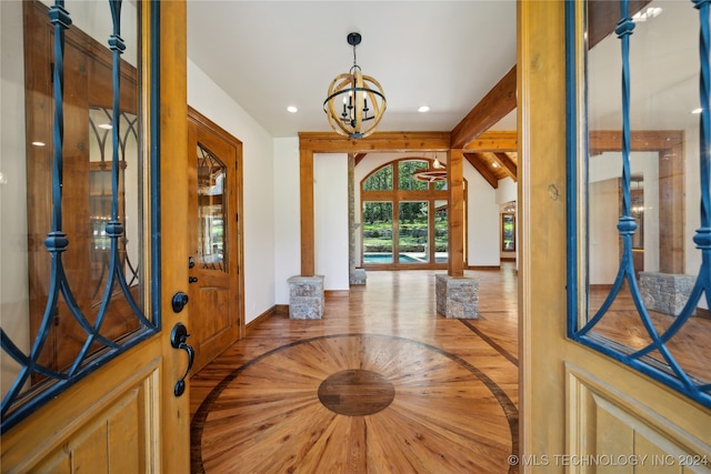 entryway featuring a chandelier and beamed ceiling