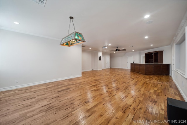 unfurnished living room with light hardwood / wood-style floors, crown molding, and ceiling fan