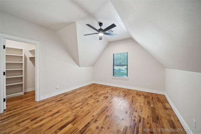 additional living space featuring ceiling fan, hardwood / wood-style floors, built in shelves, and lofted ceiling