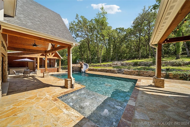 view of pool with ceiling fan, a water slide, and a patio