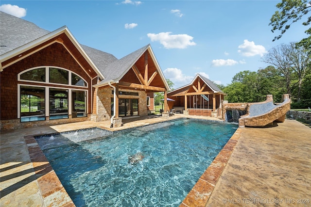 view of pool with pool water feature and a patio area