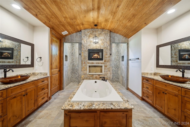 bathroom featuring vaulted ceiling, vanity, wood ceiling, and a fireplace