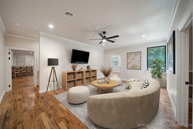 living room with ceiling fan, crown molding, and hardwood / wood-style flooring