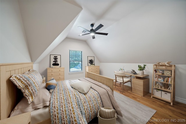 bedroom with ceiling fan, hardwood / wood-style flooring, and vaulted ceiling