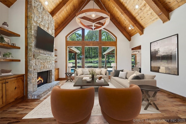 living room with high vaulted ceiling, beam ceiling, a fireplace, and light hardwood / wood-style floors