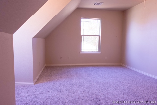 bonus room featuring lofted ceiling and light carpet