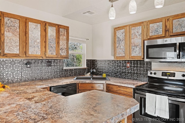 kitchen with hanging light fixtures, sink, appliances with stainless steel finishes, and tasteful backsplash