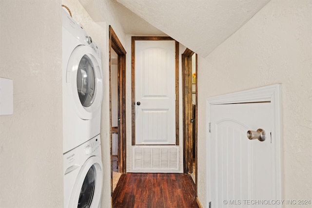 clothes washing area with dark hardwood / wood-style flooring, a textured ceiling, and stacked washing maching and dryer