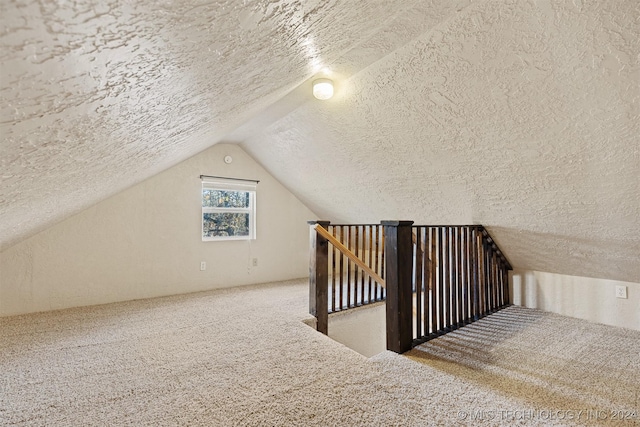 bonus room with vaulted ceiling, carpet, and a textured ceiling