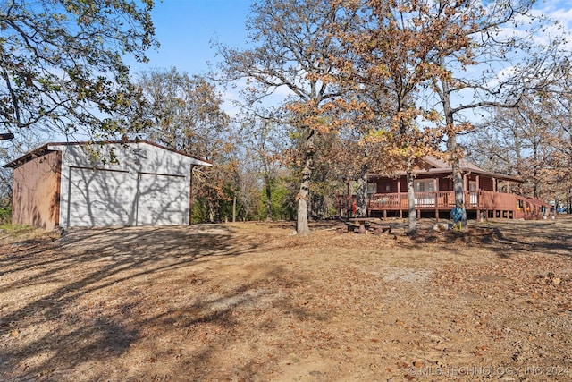 view of yard with a garage, an outdoor structure, and a deck