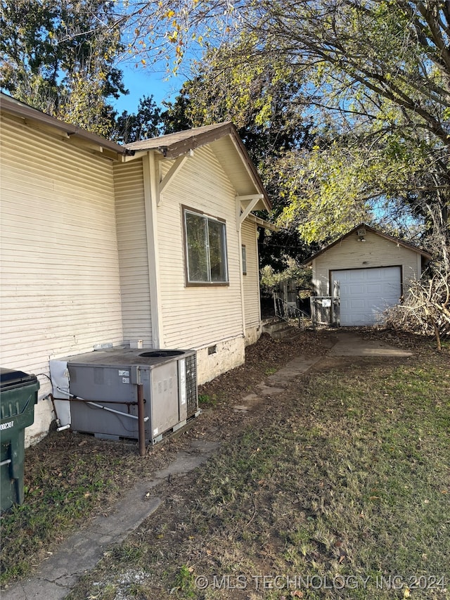 view of property exterior featuring central air condition unit, an outdoor structure, and a garage