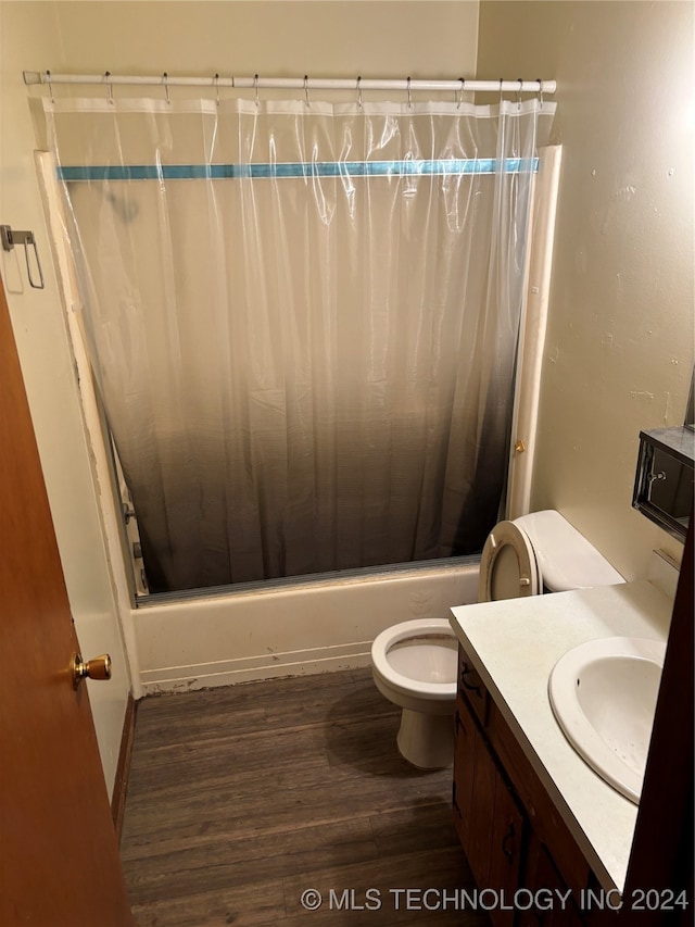 full bathroom featuring hardwood / wood-style flooring, shower / bath combination with curtain, toilet, and vanity