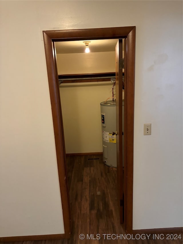 interior space with dark hardwood / wood-style flooring and water heater