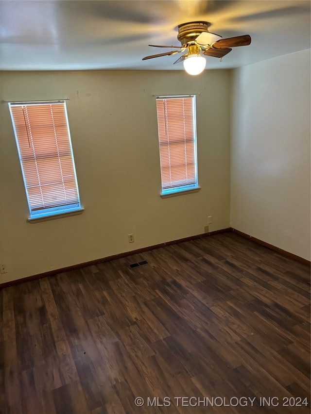 unfurnished room with ceiling fan and dark hardwood / wood-style flooring