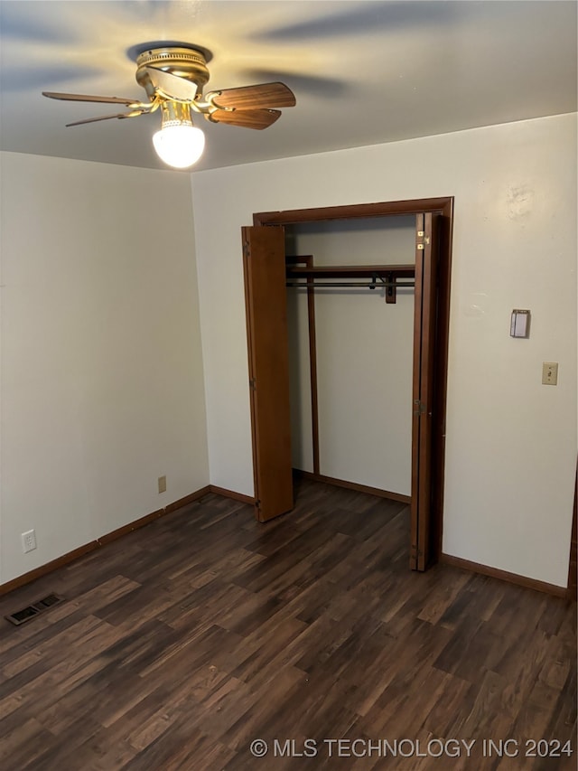 unfurnished bedroom with dark hardwood / wood-style flooring, a closet, and ceiling fan