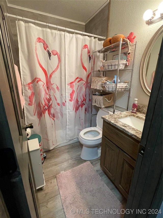 bathroom with hardwood / wood-style floors, vanity, crown molding, toilet, and a textured ceiling